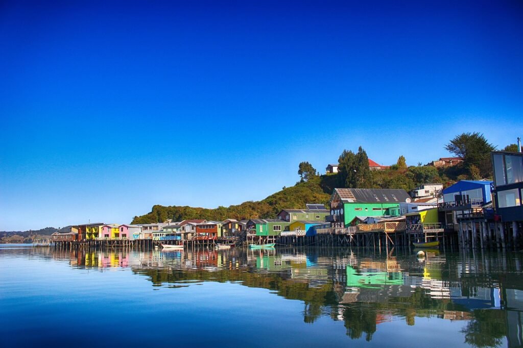 Estas icónicas casas de madera de colores construidas sobre el mar son el gran emblema de la Isla Grande de Chiloé. Un paisaje único y lleno de magia que captura la verdadera esencia de la arquitectura tradicional del sur de Chile.